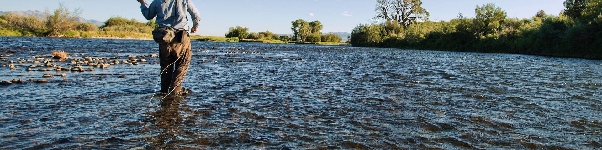 Ennis showing a river or creek and fishing as well as an individual male