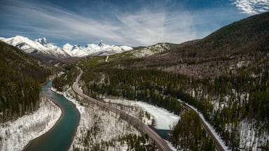 Snow-capped mountains with a river and forest in Essex, Montana, USA