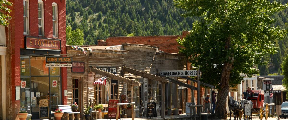 A historic downtown street with vintage buildings, including a theater and a jewelry store.