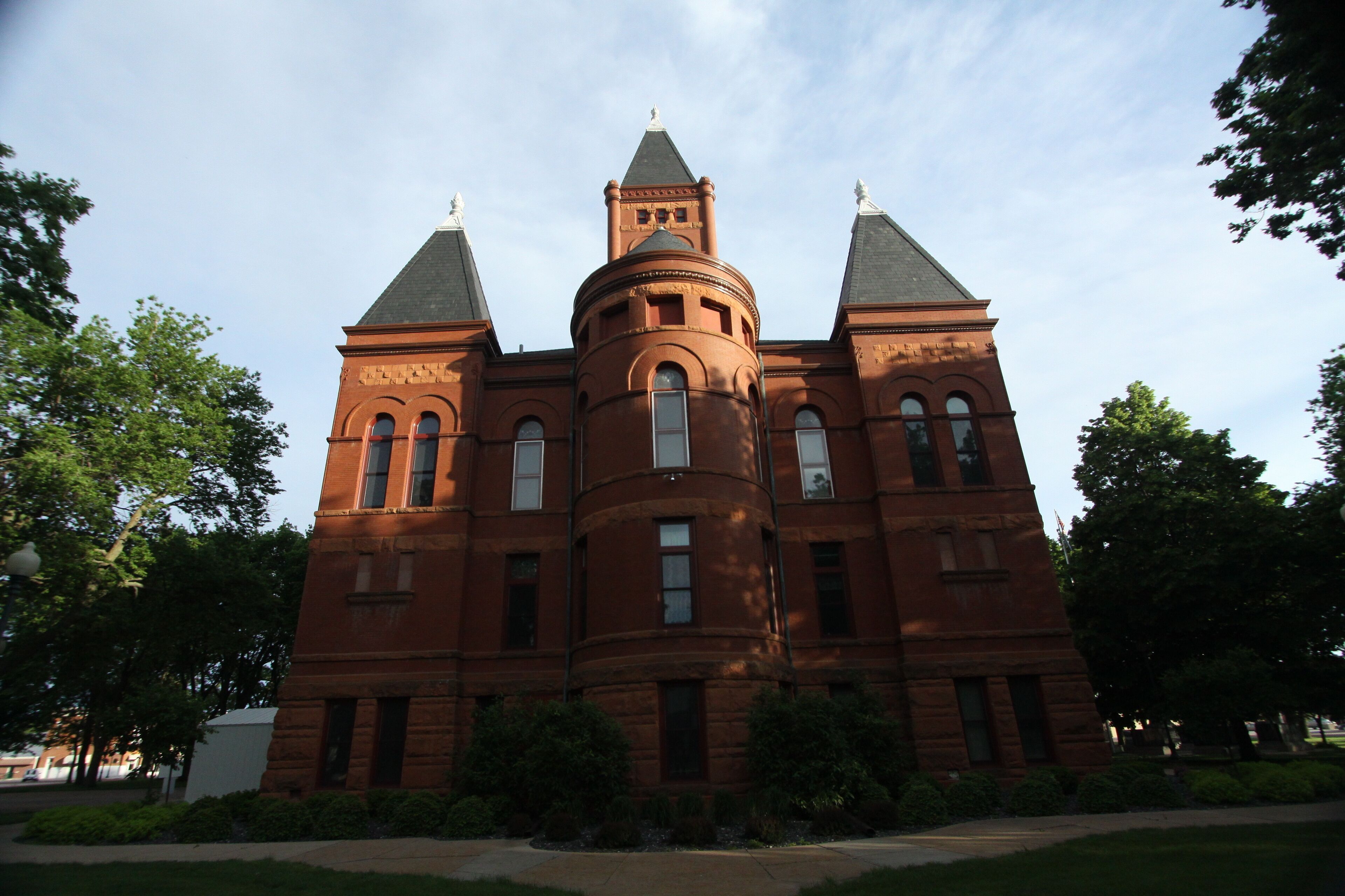 A large brick building with a central tower and two smaller towers on either side.
