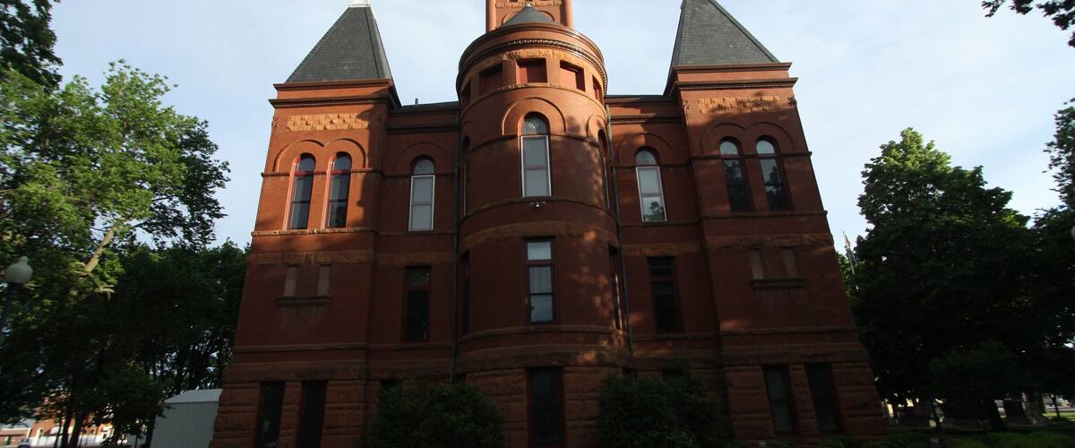 A large brick building with a central tower and two smaller towers on either side.
