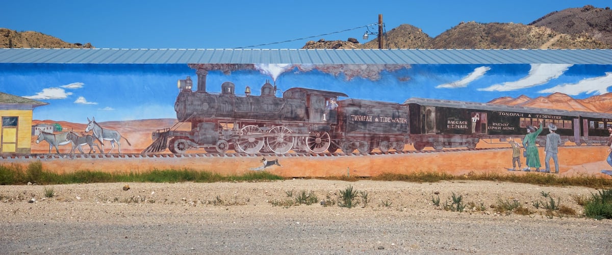 A mural of a steam locomotive with passengers and a station.