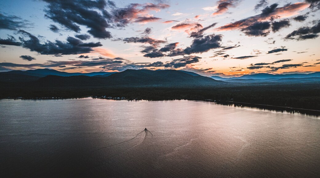 Boat travels on Ossipee Lake, New Hampshire at sunset