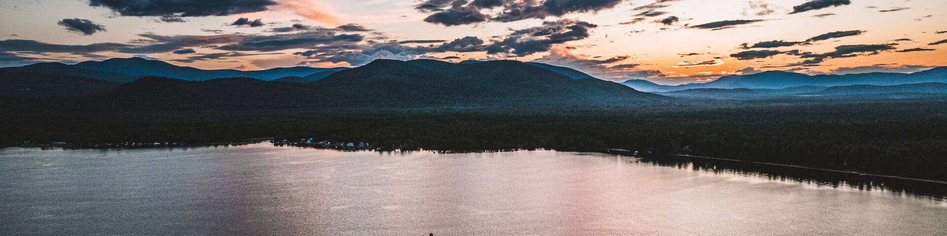 Boat travels on Ossipee Lake, New Hampshire at sunset