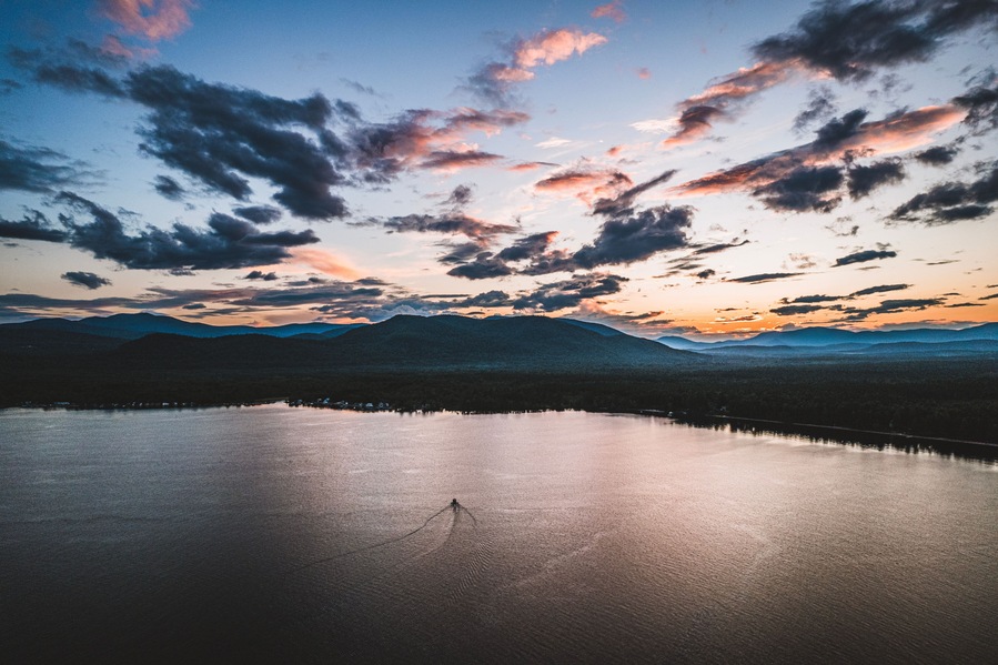 Boat travels on Ossipee Lake, New Hampshire at sunset