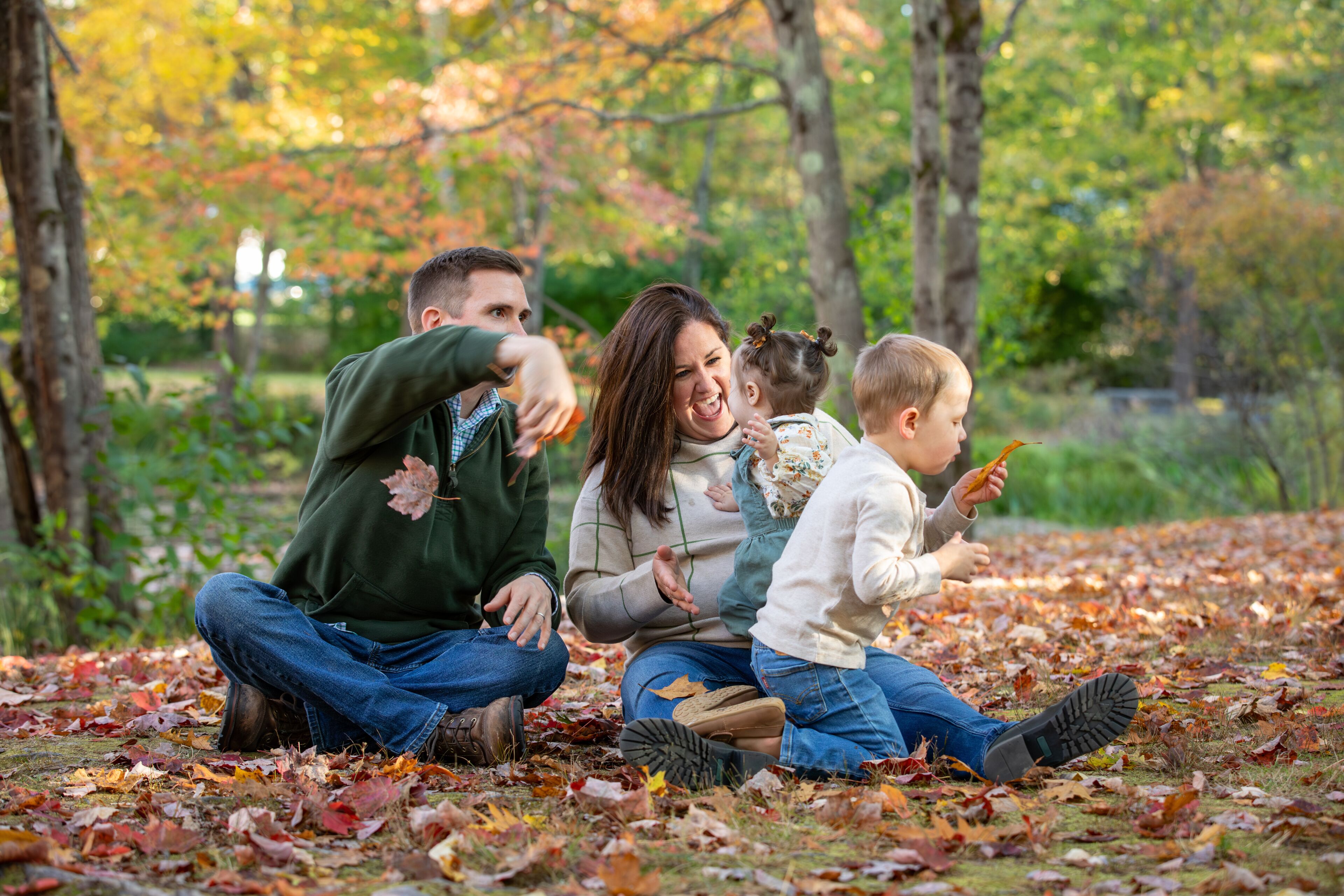 A family playing with leaves on an autumn day
