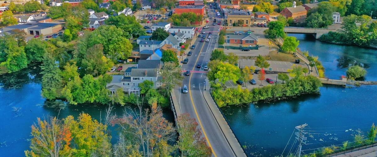 A town with a river, a bridge, and a church steeple.