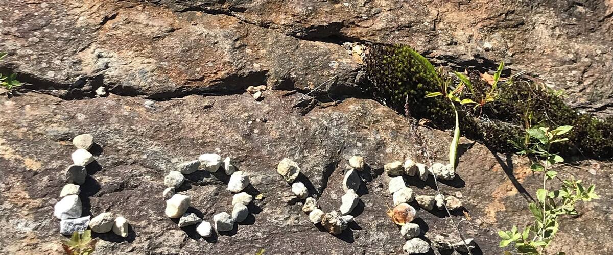 A rocky terrain with a cairn formation spelling out 'LOUIS'.