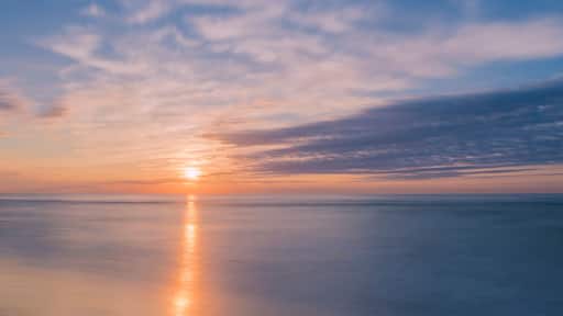 Tranquil sunrise over Avon By The Sea beach in New Jersey shot using slow shutter speed