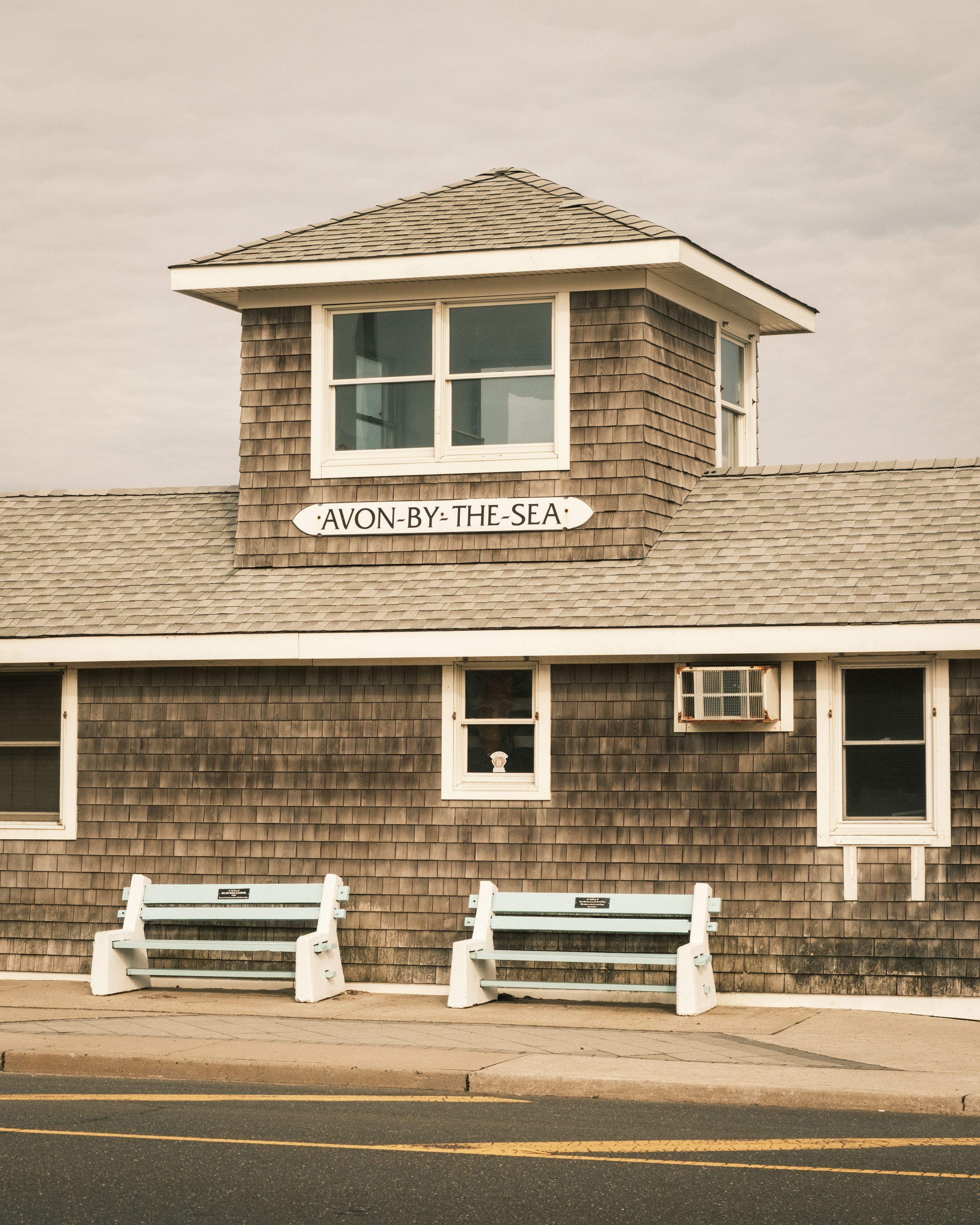 A quaint beachside building with benches and street signs in Avon-by-the-Sea, New Jersey