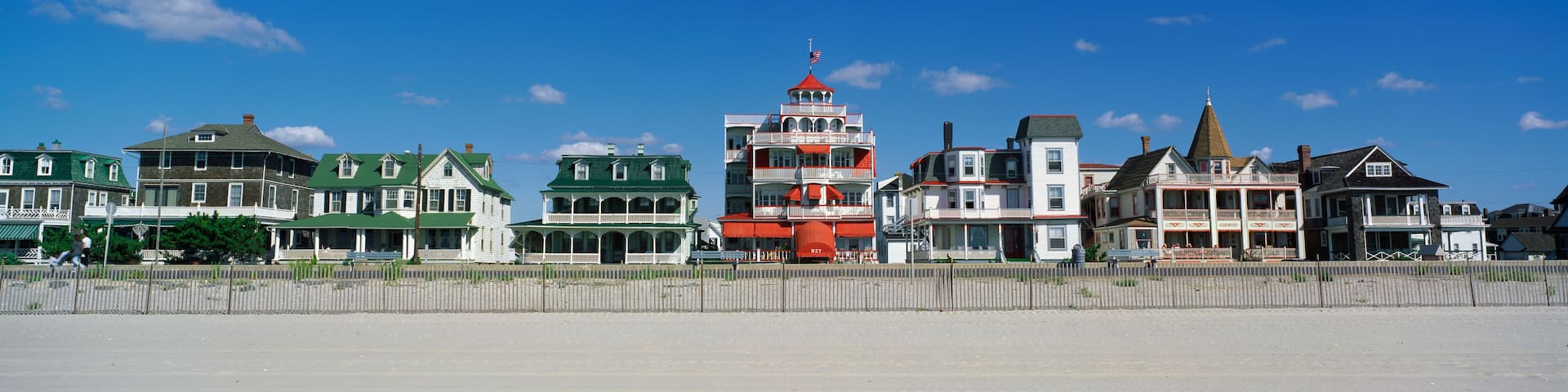 A row of historic buildings with a prominent red and white tower in the center.