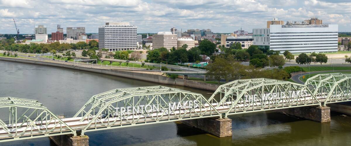 A green steel bridge over a river with the text "TRENTON, MAKES THE WORLD'S" on it.