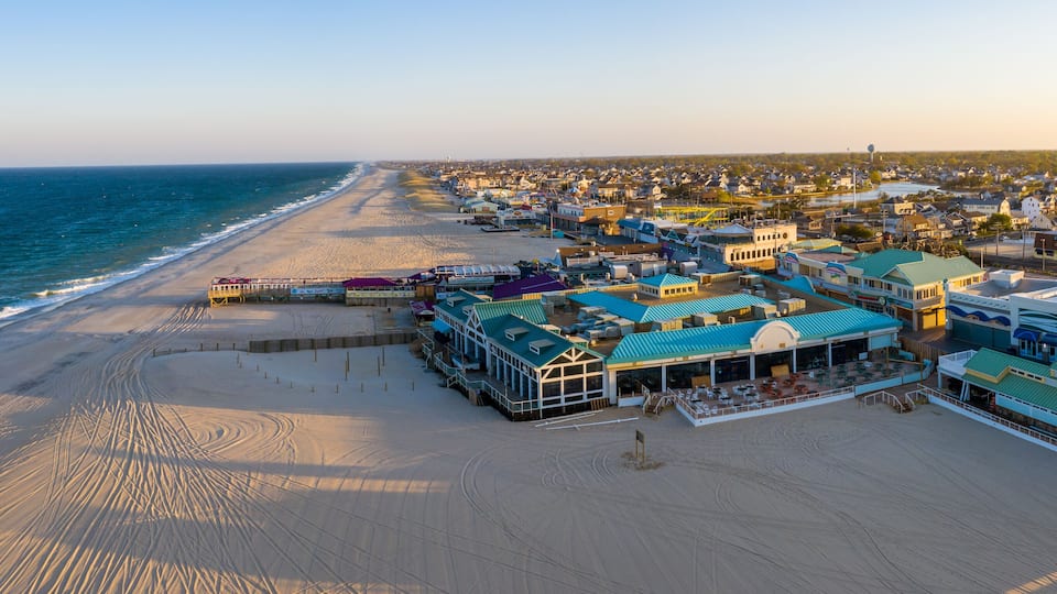 A coastal town with a beach, ocean, and various buildings.