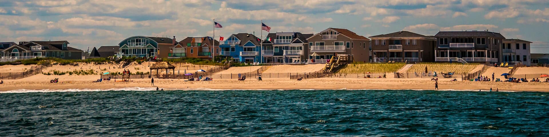 Beach houses and people on the beach in Point Pleasant, New Jersey.