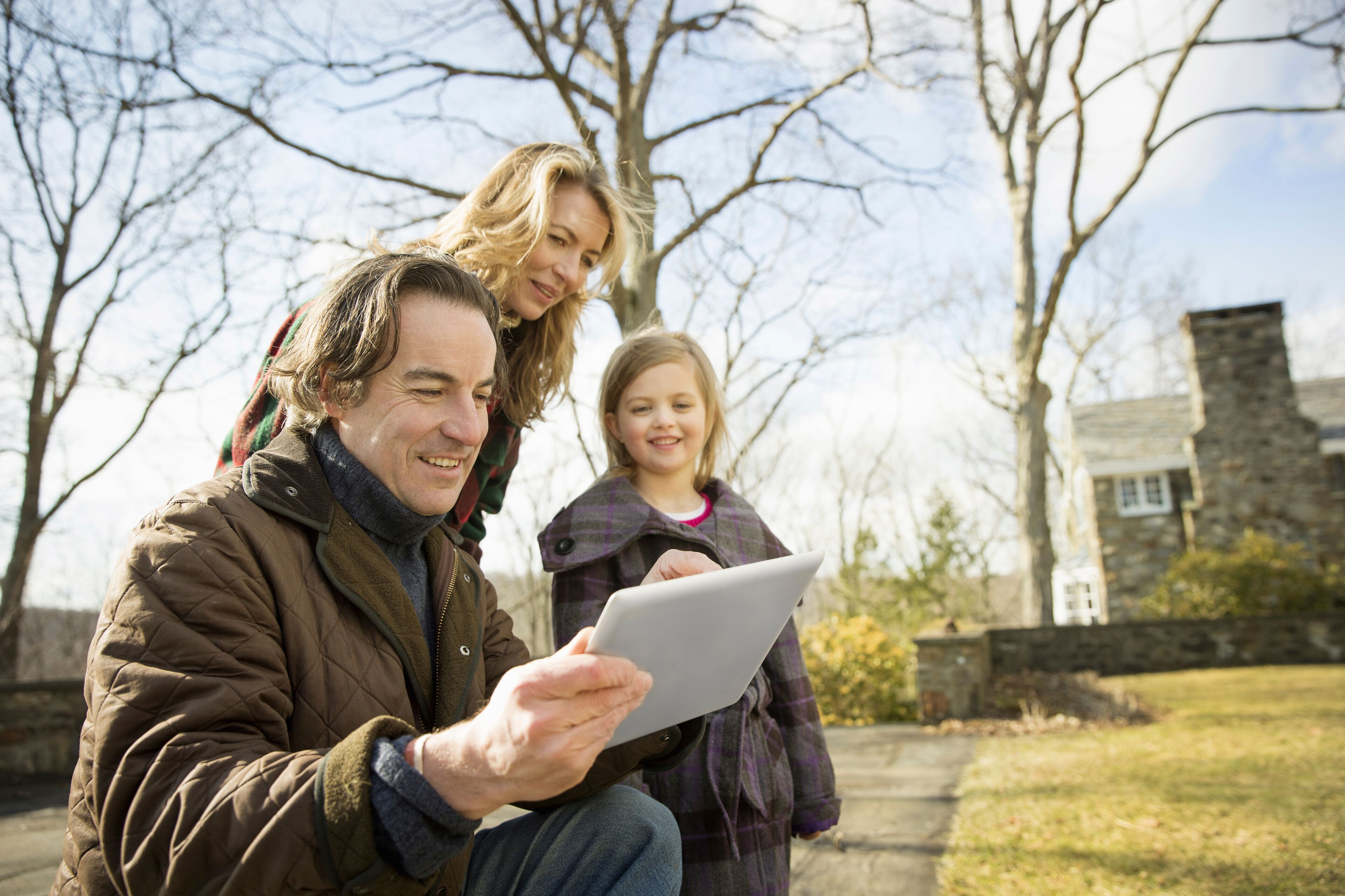An Organic Farm in Winter in Cold Spring, New York State.  A man holding a digital tablet in his hands. A woman and a child.