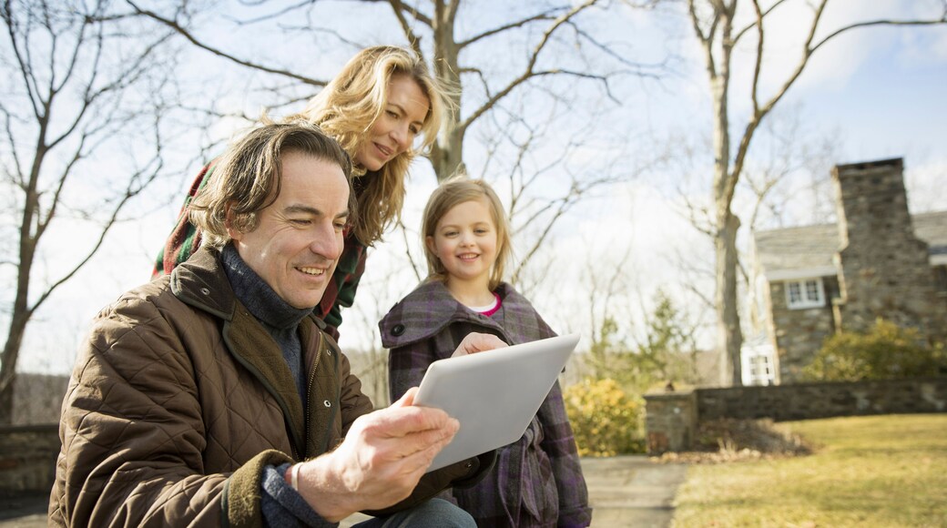 An Organic Farm in Winter in Cold Spring, New York State. A man holding a digital tablet in his hands. A woman and a child.