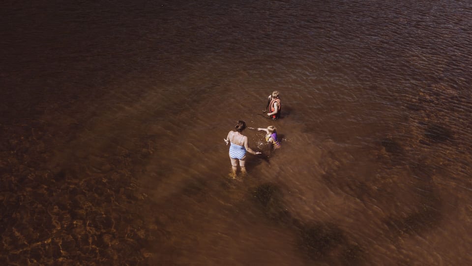 A group of people wading in shallow water.
