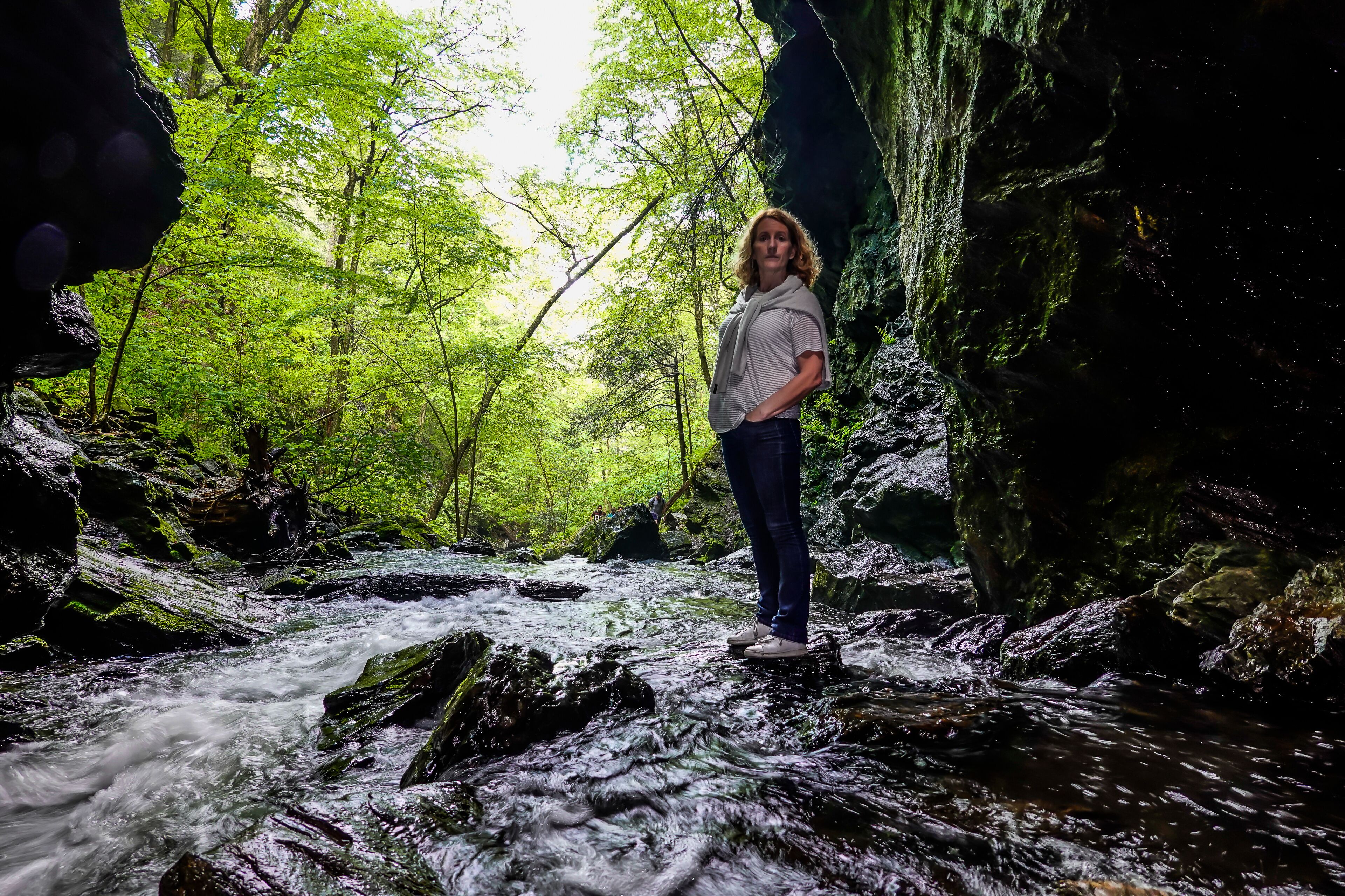 Dover Stone Church, New York, USA A woman standing in a stream of water.
