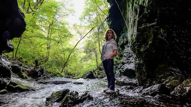 Dover Stone Church, New York, USA A woman standing in a stream of water.