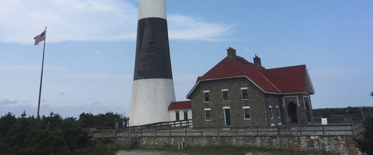 A tall lighthouse with a red-roofed building beside it.