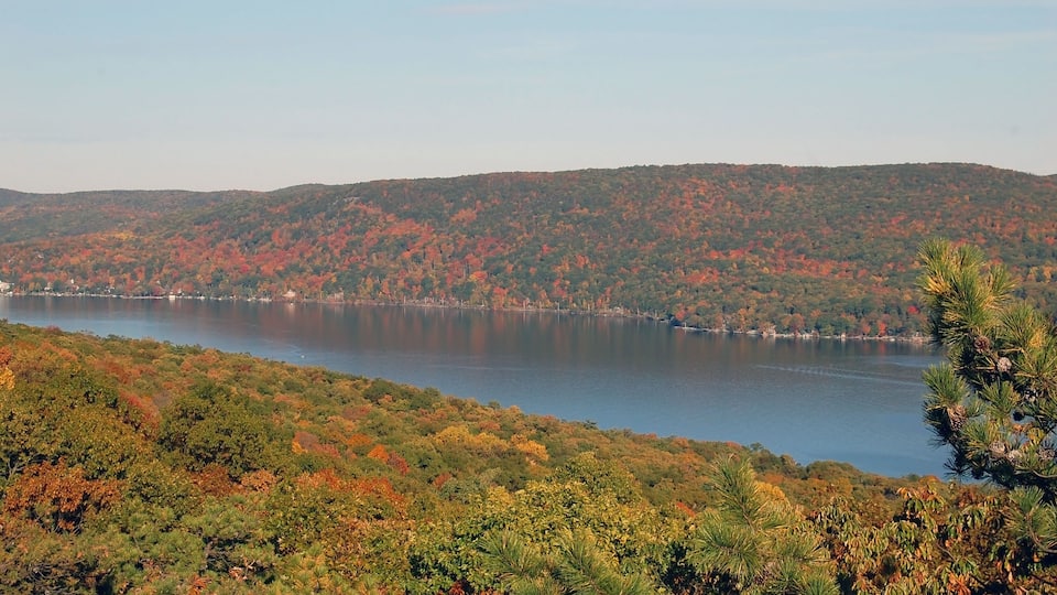 A lake surrounded by autumn-colored trees and hills.
