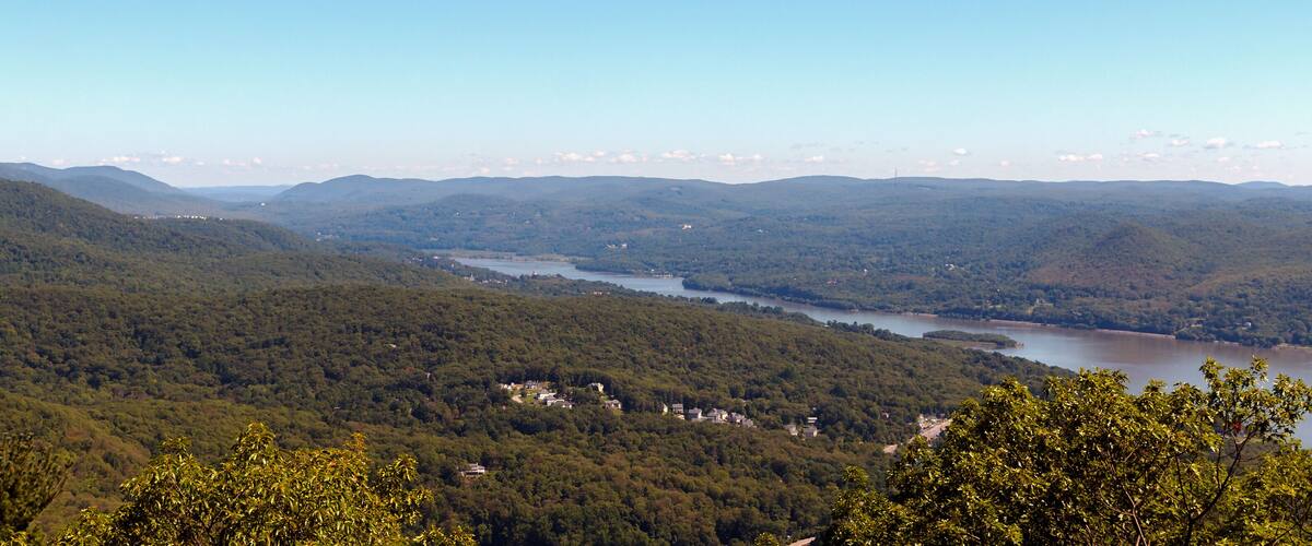 A river winding through a densely forested valley with hills in the background.