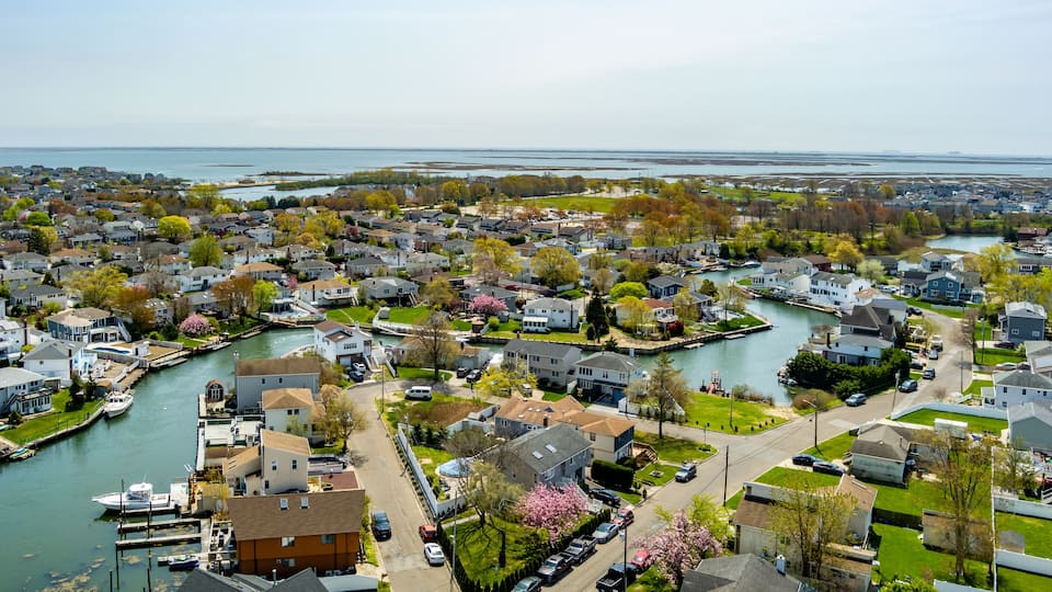 A residential area with houses, a river, and a dock with boats.