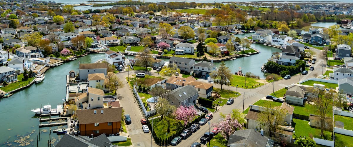 A residential area with houses, a river, and a dock with boats.