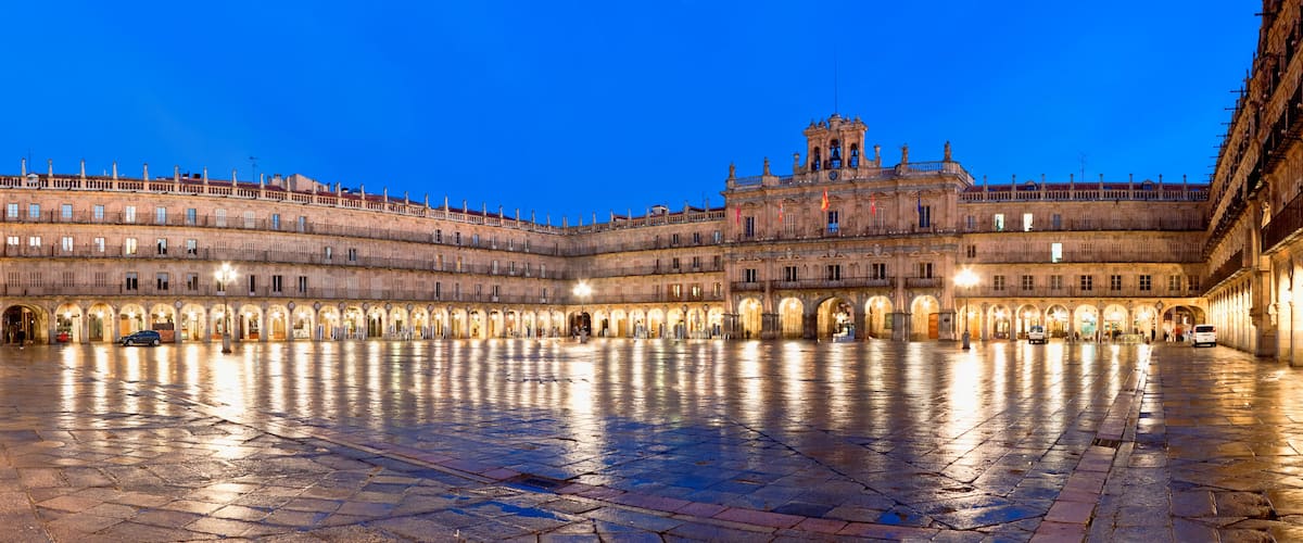 A historic plaza with a large open space, ornate buildings, and a prominent bell tower.