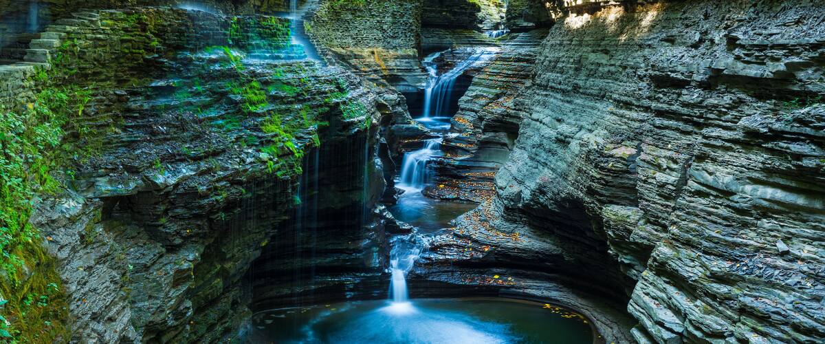 A waterfall cascading down a rocky gorge with a pool at the base.
