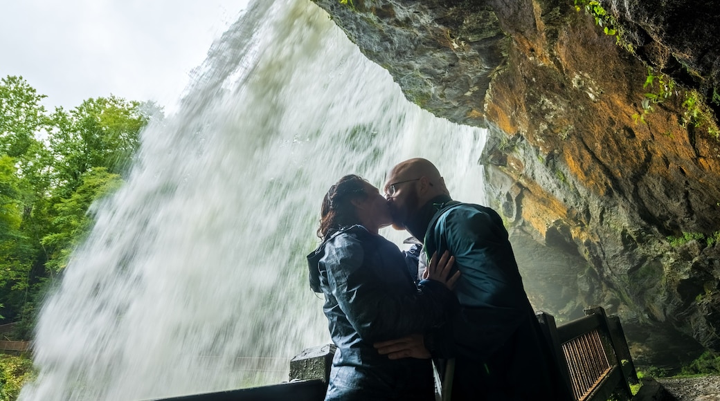 Couple kisses behind Dry Falls water fall