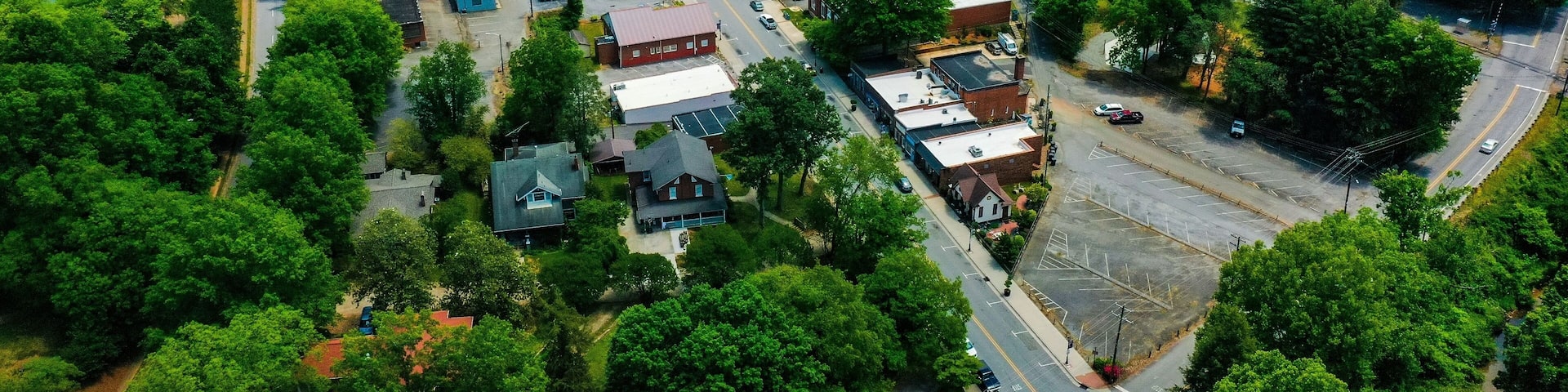 Drone shot of trees and small rural houses in the town of Elkin, North Carolina on spring day