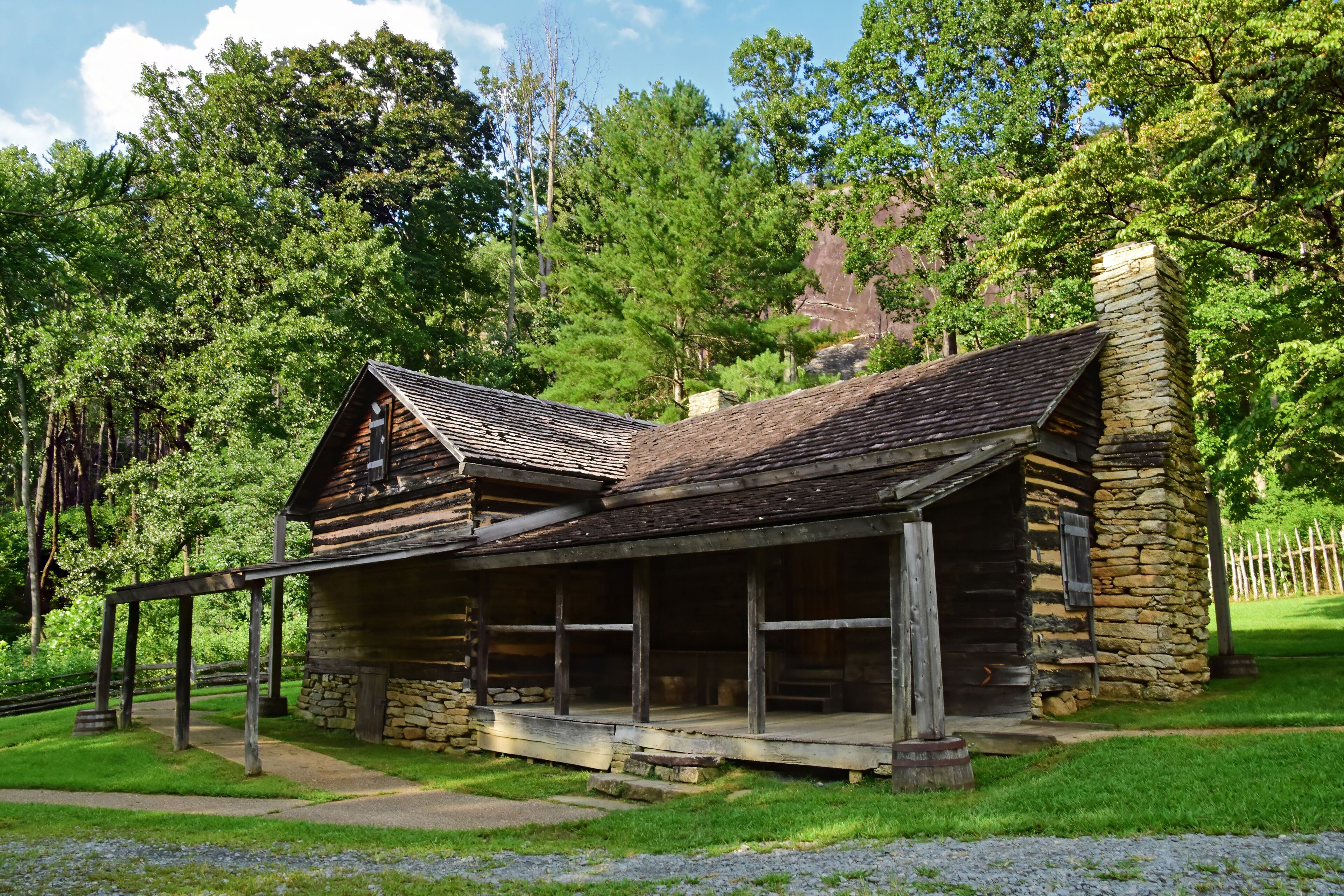 the historic 19th century log cabin home of the restored hutchinson homestead in summer along the stone mountain loop trail  in stone mountain state park,  near roaring gap, in northern north carolina