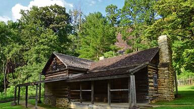 the historic 19th century log cabin home of the restored hutchinson homestead in summer along the stone mountain loop trail in stone mountain state park, near roaring gap, in northern north carolina
