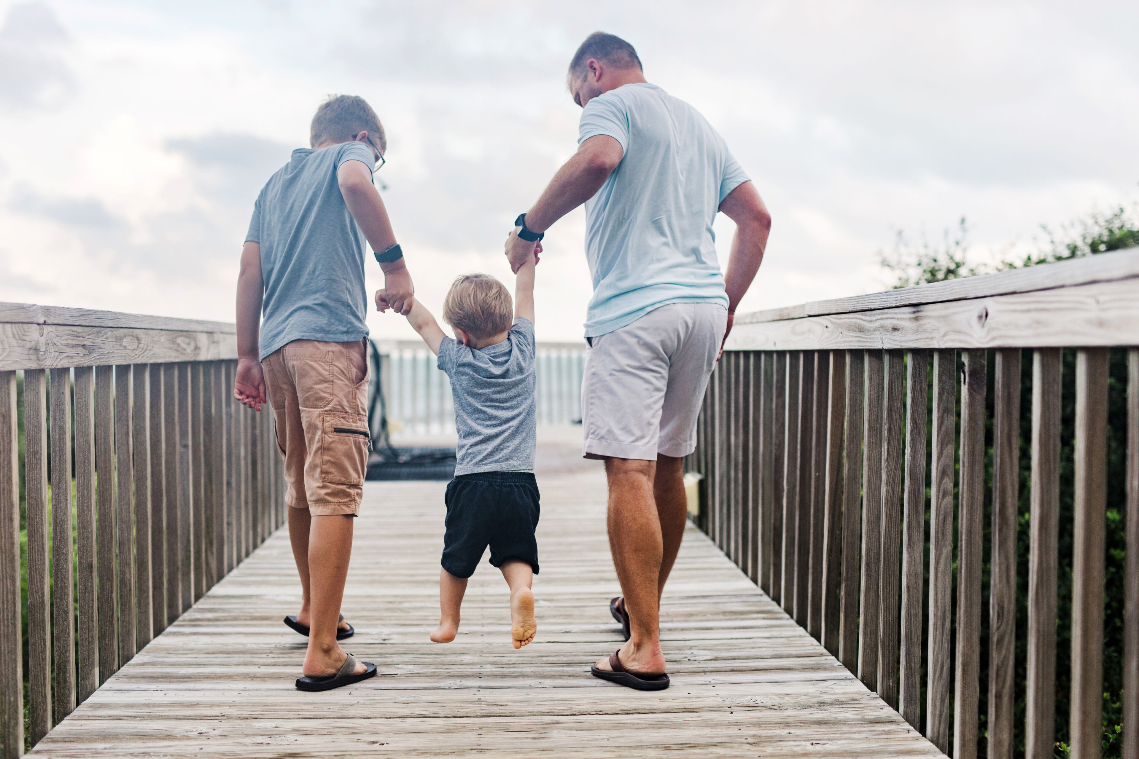 family playfully walk with toddler