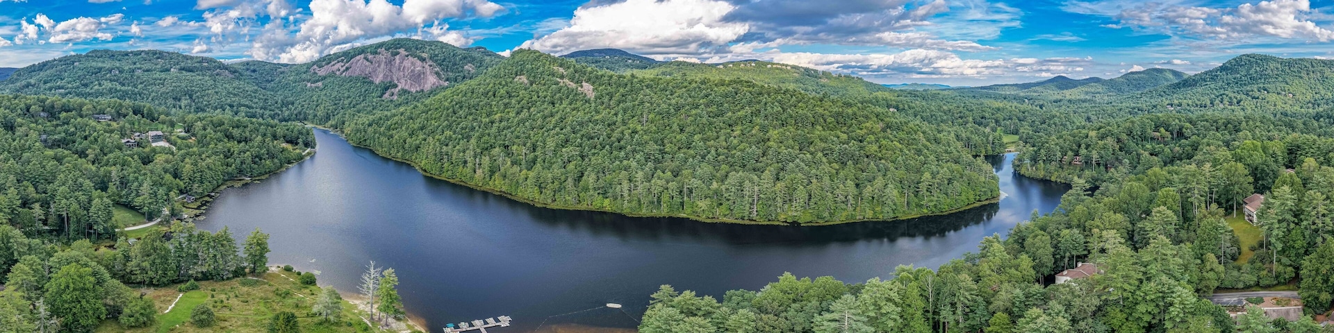 A lake surrounded by dense forest and mountains.