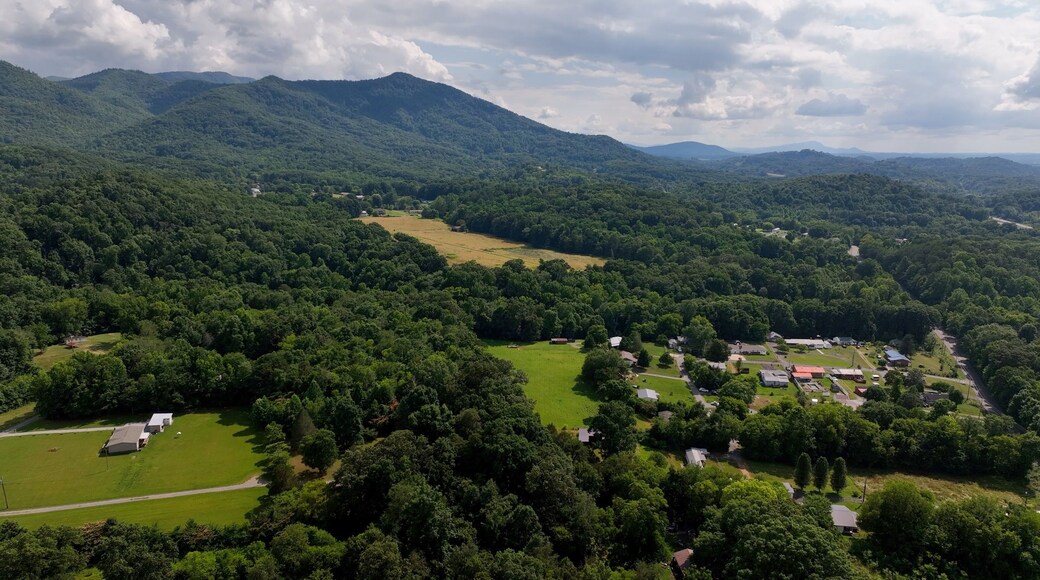 Living in a peaceful small town by the Great Smoky Mountains with green fields and trees under blue sky with clouds in North Carolina