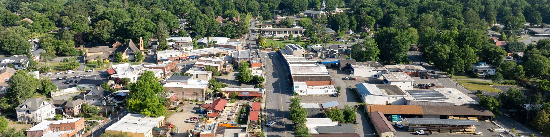 Aerial view of Black Mountain, NC, showcasing a charming town surrounded by lush green forests and mountainous landscape.
