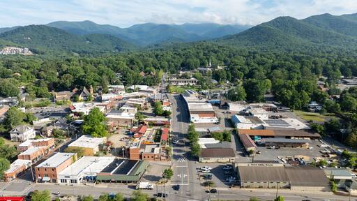 Aerial view of Black Mountain, NC, showcasing a charming town surrounded by lush green forests and mountainous landscape.