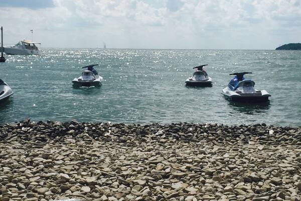 A rocky shoreline with jet skis on the water.