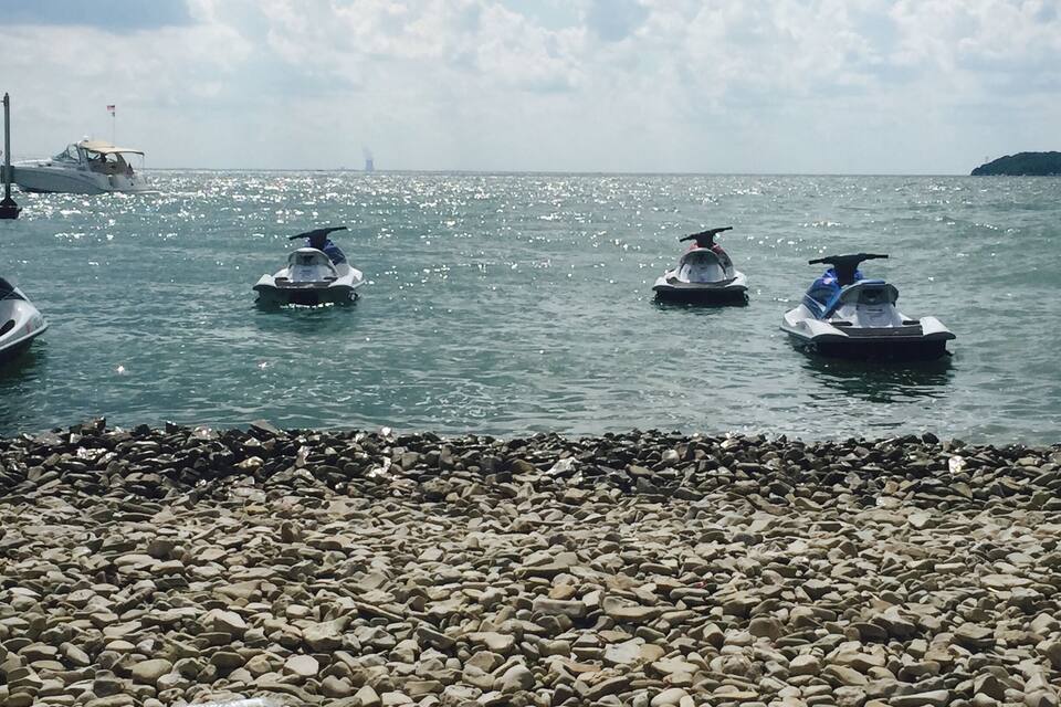 Une côte rocheuse avec des scooters des mers sur l’eau.