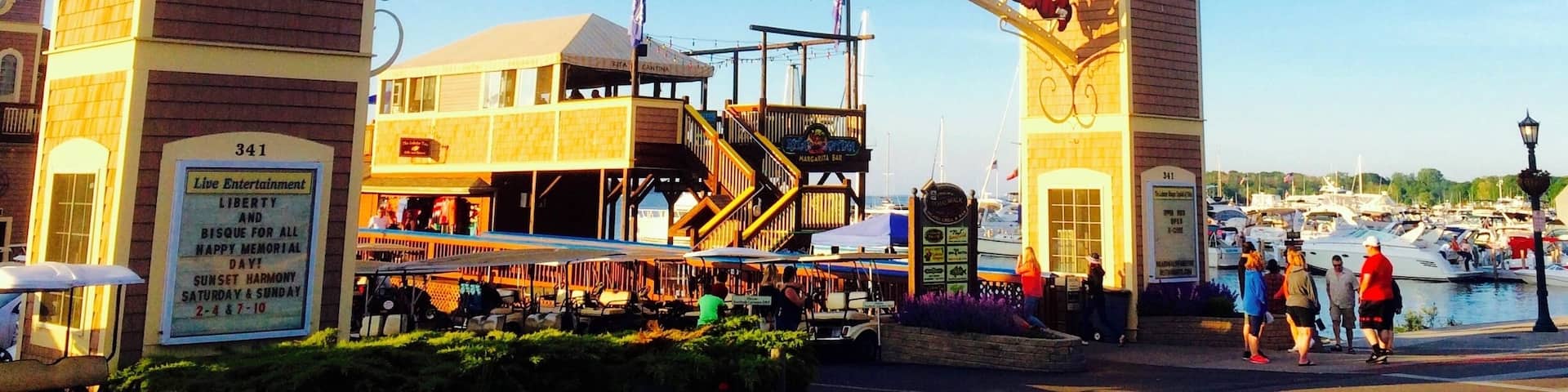 A Boardwalk entrance with a lobster sign, a Ferris wheel, and a waterfront view.