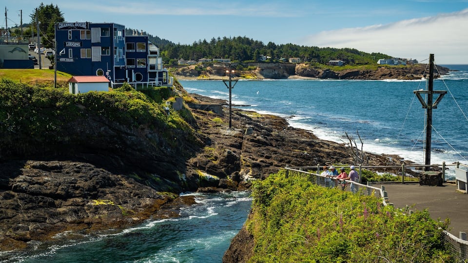 A coastal area with a Channel House lodging, rocky cliffs, and a view of the ocean.
