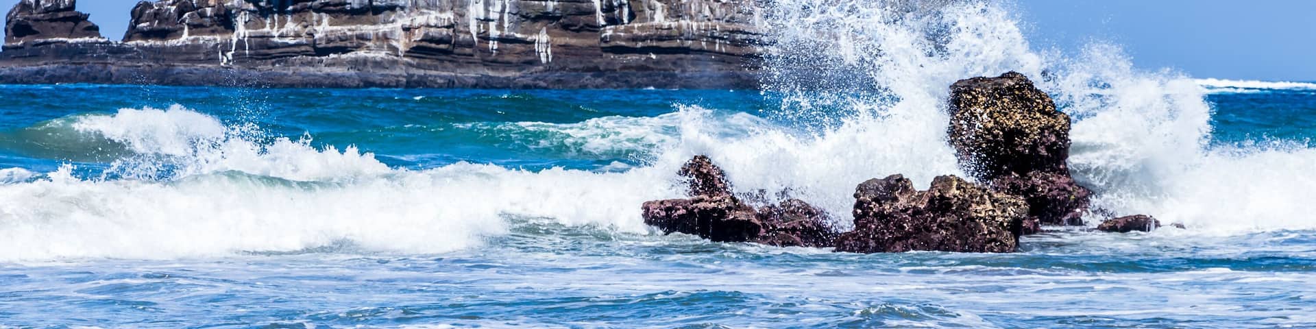 A rocky coastline with waves crashing against the rocks.