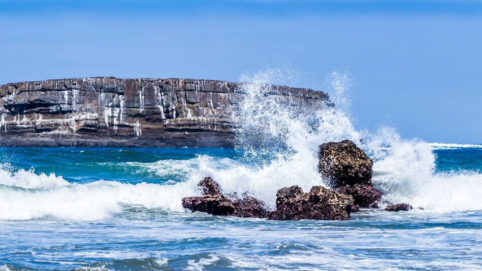 A rocky coastline with waves crashing against the rocks.