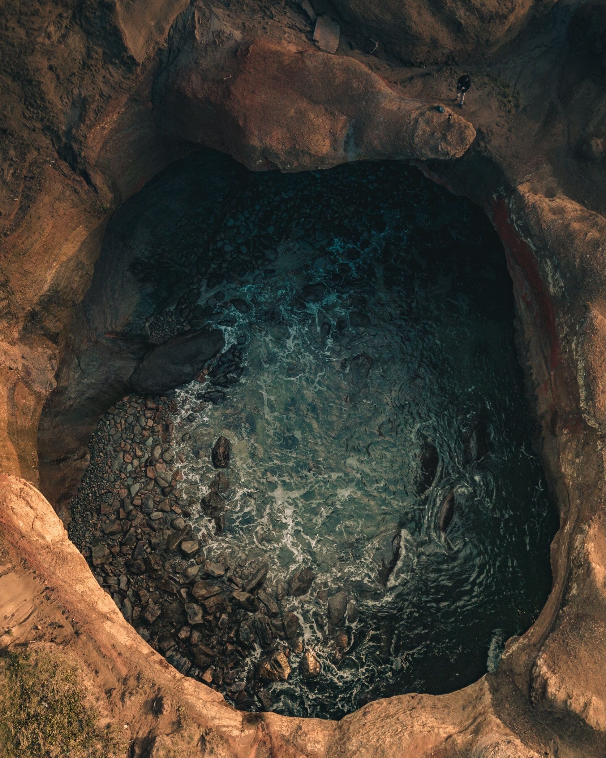 A natural pool surrounded by rocky terrain.