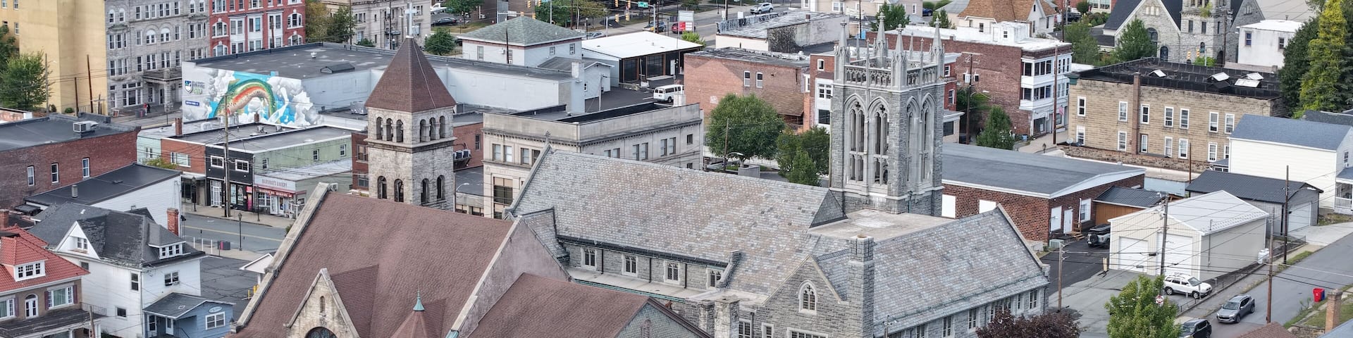 Aerial view of a grand church with its soaring tower piercing the sky above a tapestry of buildings and streets, Carbondale, Pennsylvania, United States.