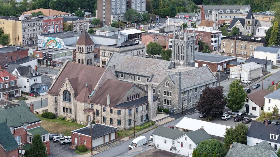 A historic church with a prominent steeple and a large mural on the side of a building.