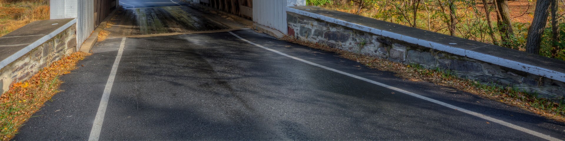 A covered bridge with a clearance sign of 11 ft 0 in.