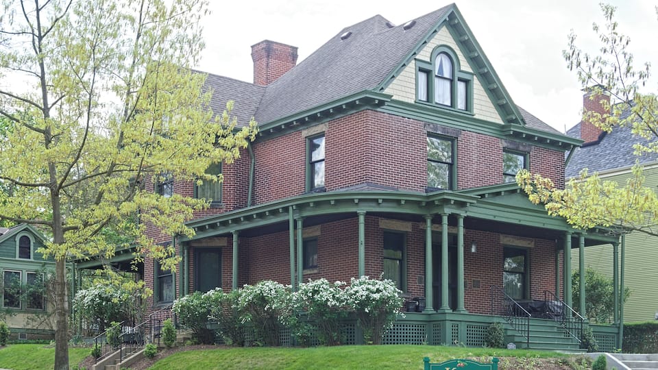 A brick house with a green porch and a sign reading "Kerr Memorial Museum".